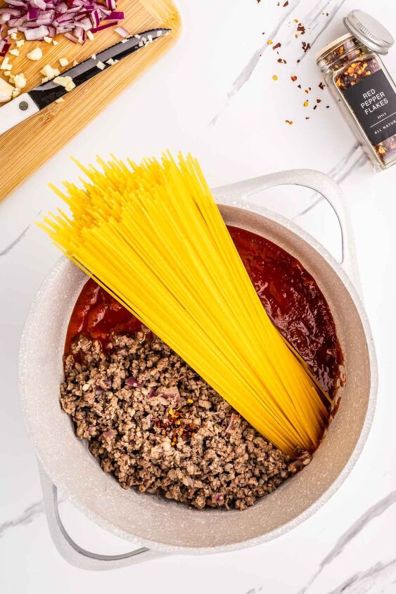 one pot spaghetti with sausage, Spaghetti broth and marinara sauce being added to the pot