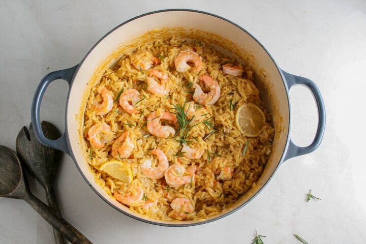 creamy rosemary orzo with shrimp, Hero photograph of creamy rosemary orzo with shrimp Photographed in a steel blue dutch oven with wooden serving utensils on the side