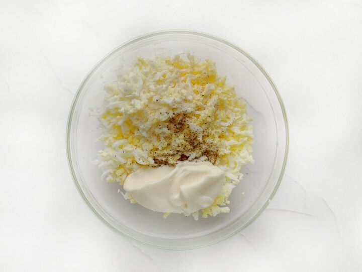 russian cheese salad recipe, grated egg and mayonnaise in a bowl