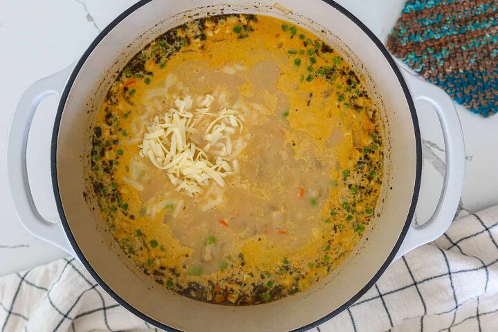 hamburger potato soup delicious easy, Adding shredded cheese to pot of hot soup