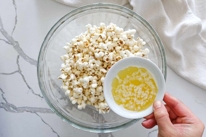 Pouring melted butter over popcorn