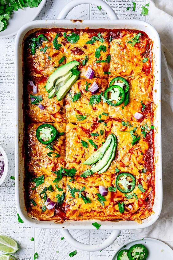 vegetarian enchilada casserole, enchilada casserole served in a casserole dish topped with avocado and jalapenos