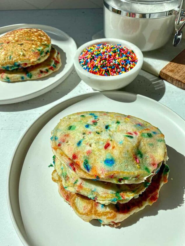 funfetti pancakes happy honey kitchen, Two stacks of funfetti pancakes on white plates with a bowl of rainbow sprinkles on the side
