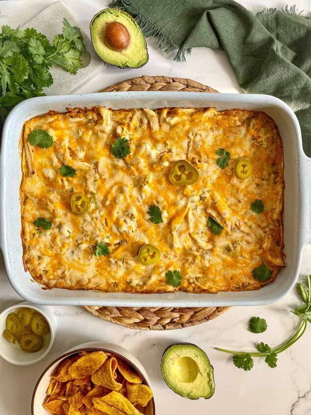 sour cream chicken enchilada casserole happy honey kitchen, Sour Cream Chicken Enchilada Casserole in a large baking dish A green kitchen towel cilantro avocado and chips are around the dish