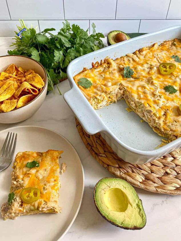 sour cream chicken enchilada casserole happy honey kitchen, Sour Cream Chicken Enchilada Casserole cut into with one serving of the layered chicken casserole on a plate Cilantro avocado and chips surround the meal