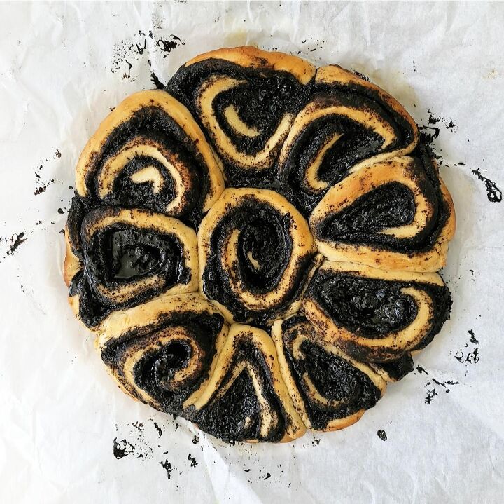 oreo cinnamon rolls, oreo cinnamon rolls top down view of ten baked rolls in the circular shape of the baking pan rolls are swirled with black cocoa powder background is white parchment paper