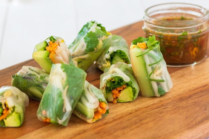 Vegetable rice paper rolls on wooden board with dressing