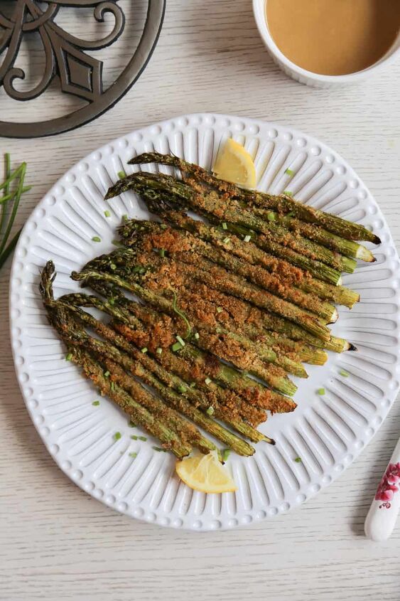 air fryer asparagus recipe, air fryer asparagus on a plate with lemon wedges