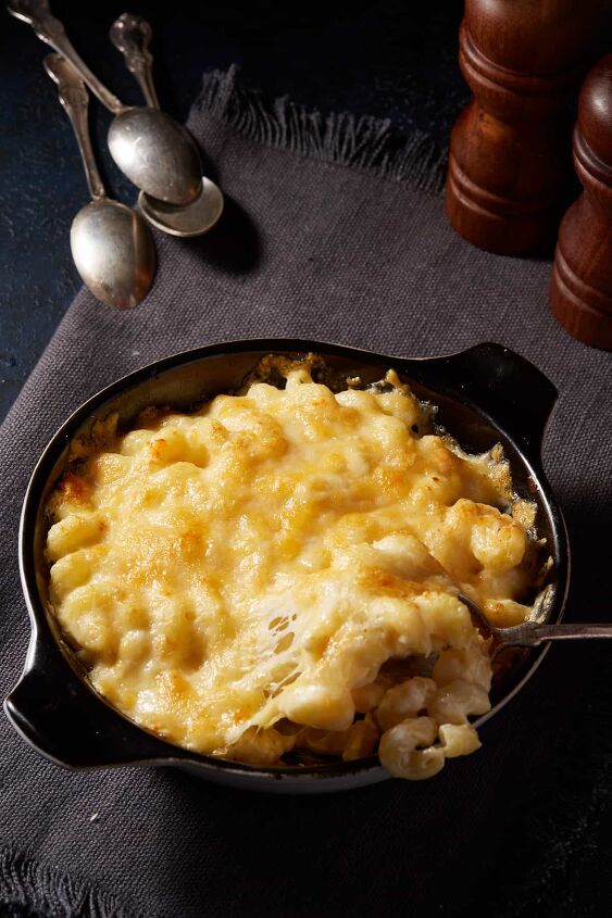 old fashioned macaroni and cheese recipe, A casserole dish of mac and cheese on a grey linen napkin