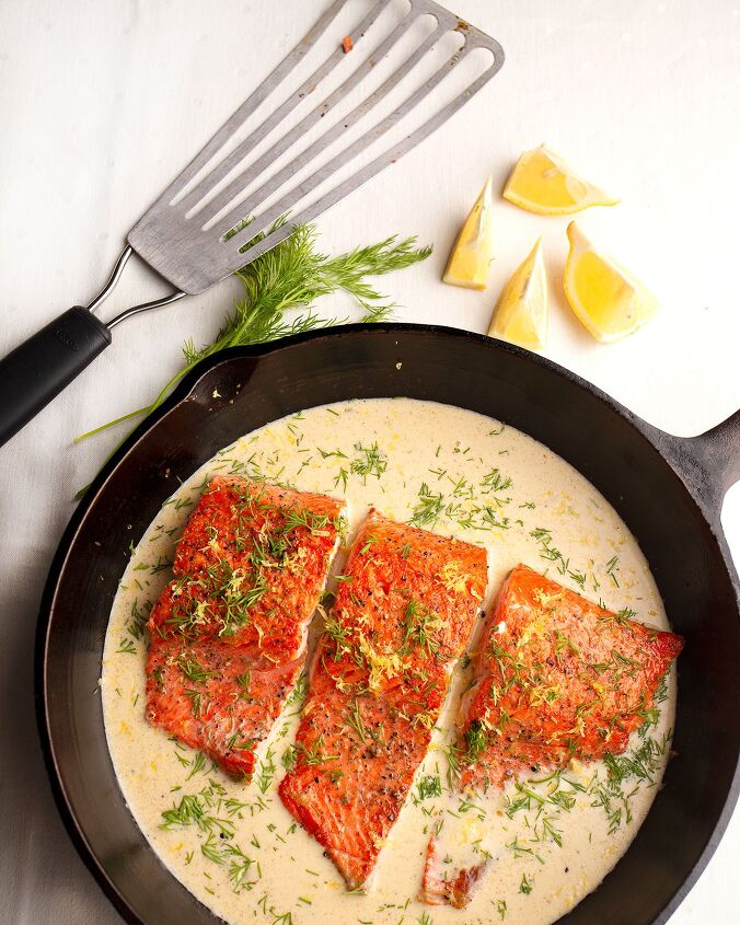 honey mustard salmon, Cast iron skillet with salmon fillets a fish spatula and lemon wedges