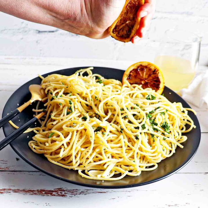 easy lemon garlic pasta pasta al limone, Hand squeezing grilled lemon on pasta