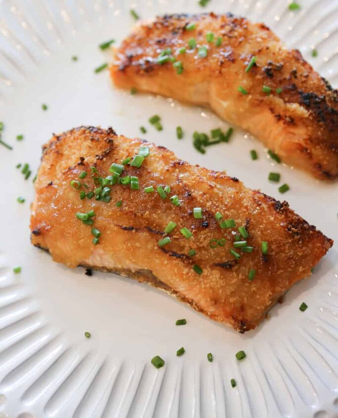 air fryer salmon with dijon mustard sauce, air fryer salmon with dijon mustard sauce garnished with chives on a white plate