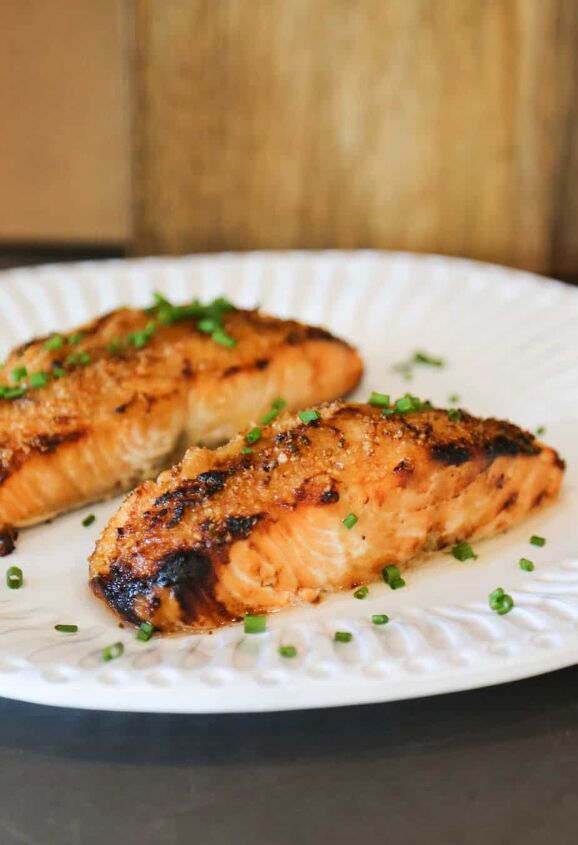 air fryer salmon with dijon mustard sauce, air fryer salmon with dijon mustard sauce garnished with chives on a white plate