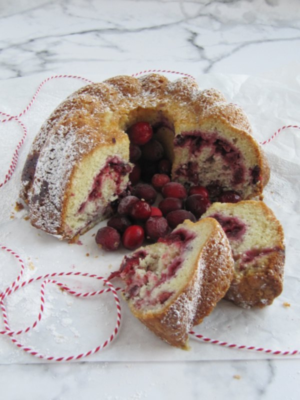 cranberry bundt cake, cranberry swirl bundt cake with 2 slices on a marble counter