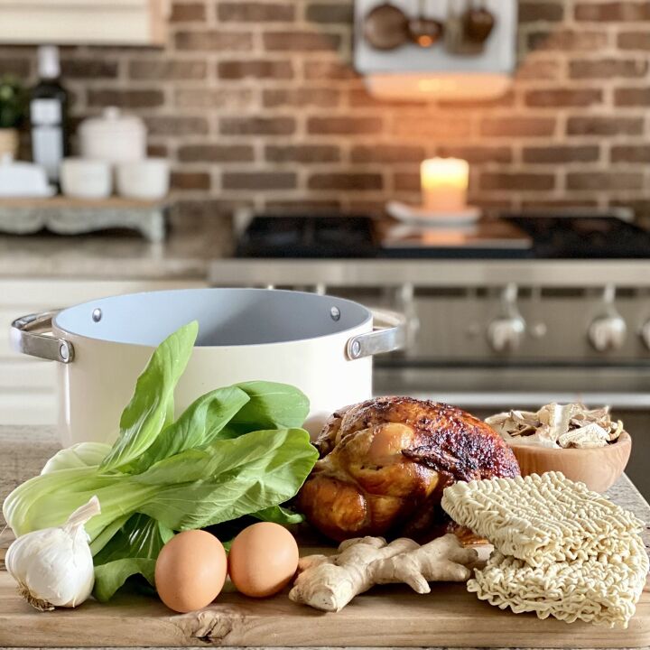 easy weeknight chicken ramen, Some the ingredients in easy weeknight chicken ramen including rotisserie chicken ramen noodles fresh bok choy and more set out on the kitchen island in front of the stove with a soup pot