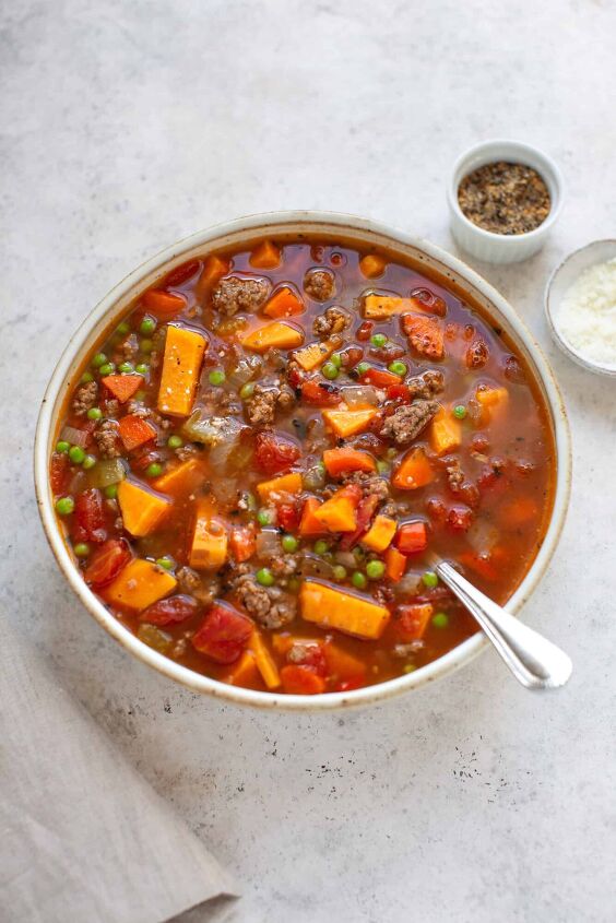 easy hamburger soup, vegetable soup with hamburger in a bowl and spices on the side