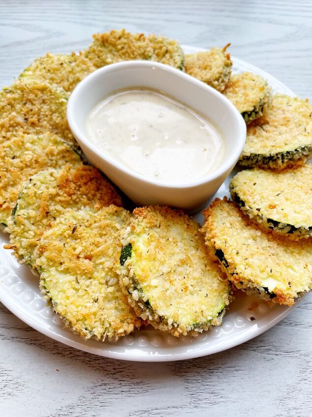 easy oven baked zucchini chips, baked zucchini chips with a small bowl of ranch dip