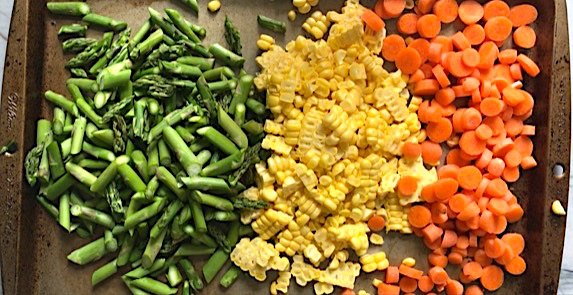 roasted vegetable pasta primavera recipe, Raw cut asparagus corn kernels and sliced carrots on a sheet pan for Creamy Pasta Primavera It has fettuccine parmesan cheese roasted asparagus carrots tomatoes and fresh corn kernels