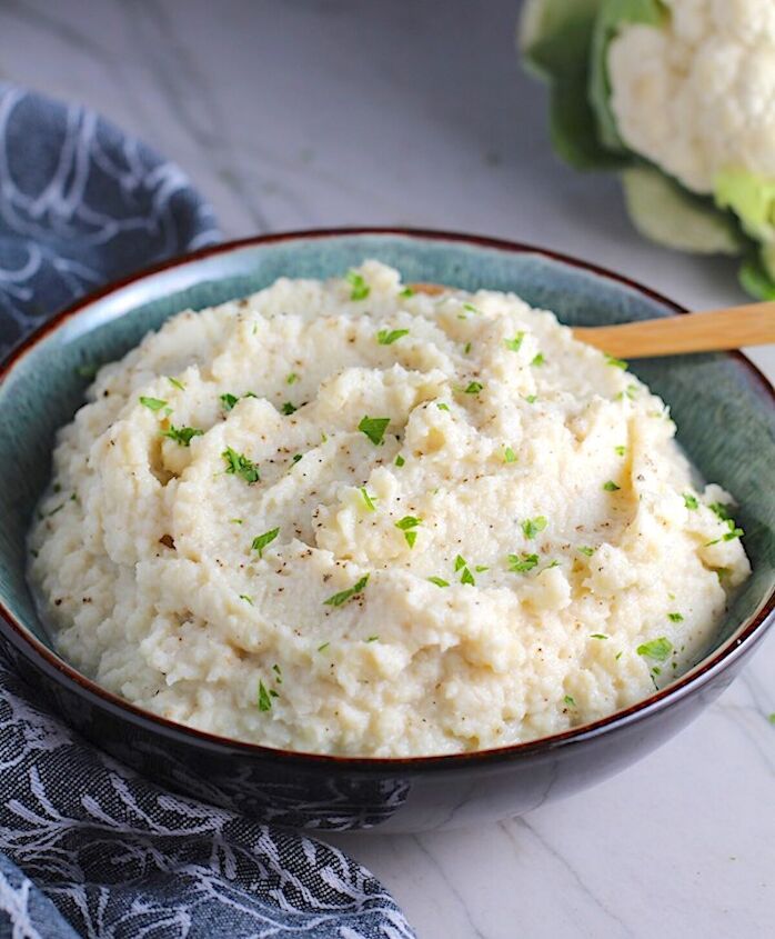 easy mashed roasted cauliflower and garlic, Mashed Roasted Cauliflower in a bowl with spoon The texture is perfectly creamy and along with the flavor mimics mashed potatoes