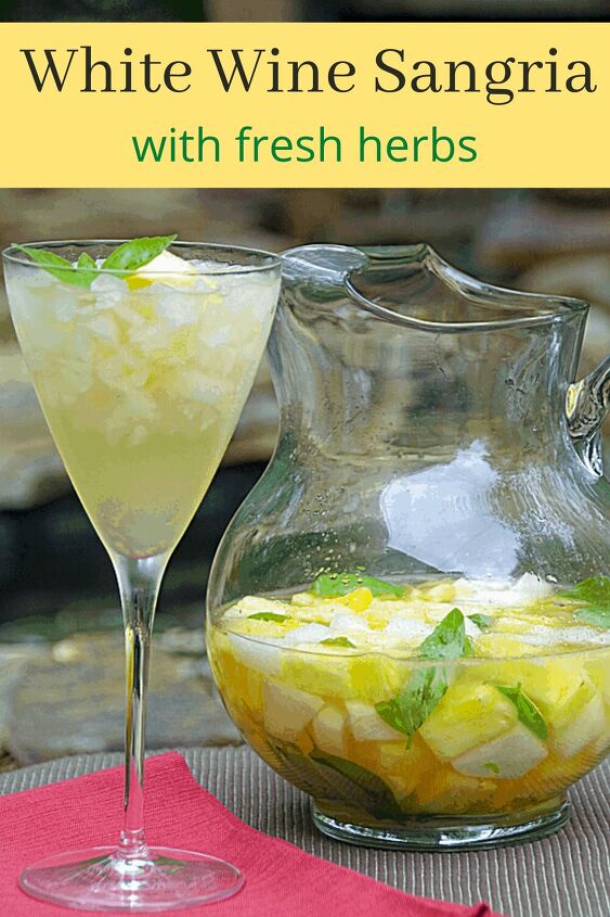 white wine sangria recipe with fresh herbs, white wine sangria in pitcher next to glass with homemade sangria in it