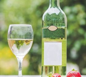 white wine sangria recipe with fresh herbs, bottle of white wine and glass of wine with strawberries on table