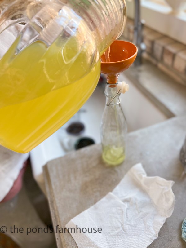 Pour Limoncello Recipe into decorative bottles using a funnel