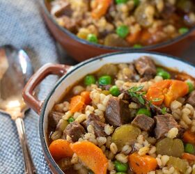 instant pot beef barley soup crockpot stove top, Two soup bowls filled with beef and barley soup There s a spoon on top of a textured napkin next to the soup The soup has peas and carrots in it