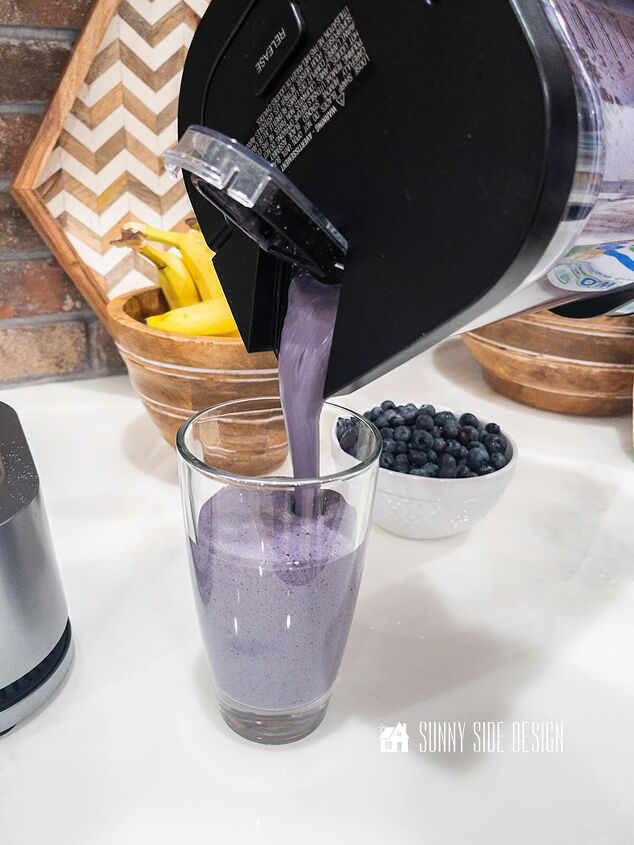 the best superfood blueberry banana smoothie, Pouring Blueberry banana smoothie into a clear glass