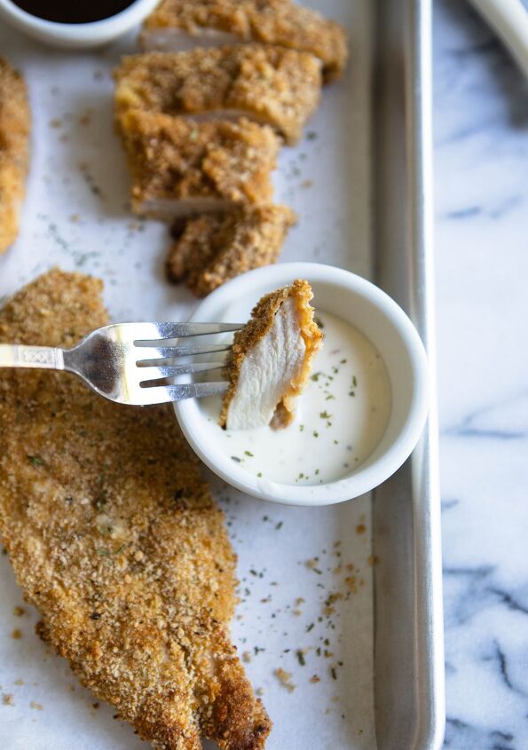 chicken cutlets in the air fryer, A piece of chicken cutlet cooked in air fryer dipped in ranch dressing
