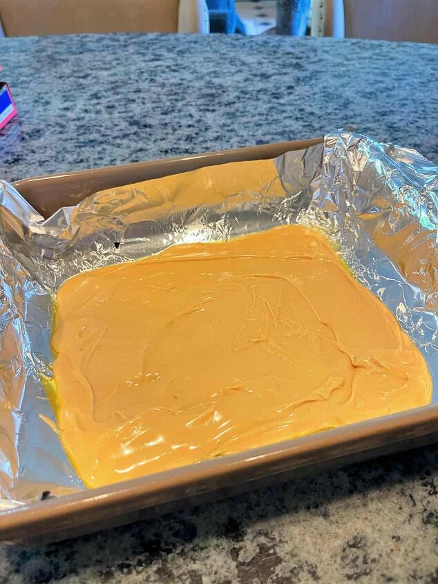 tiger butter fudge recipe easy, before pouring the melted semi sweet chocolate on top close up of melted white chocolate in baking dish