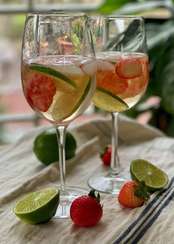 3 white wine spritzer recipes you should try, Strawberry Limeade Spritzer close up with limes and strawberries on a farmhouse dishtowel