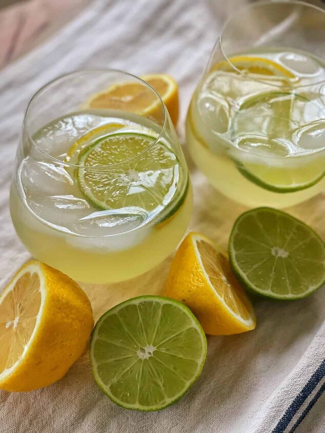 3 white wine spritzer recipes you should try, lemon lime spritzer recipe in stemless wine glasses with limes and lemons on farmhouse towel