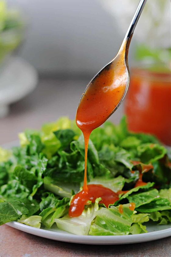 homemade sweet catalina dressing, spoonful of sweet catalina dressing pouring onto a lettuce salad