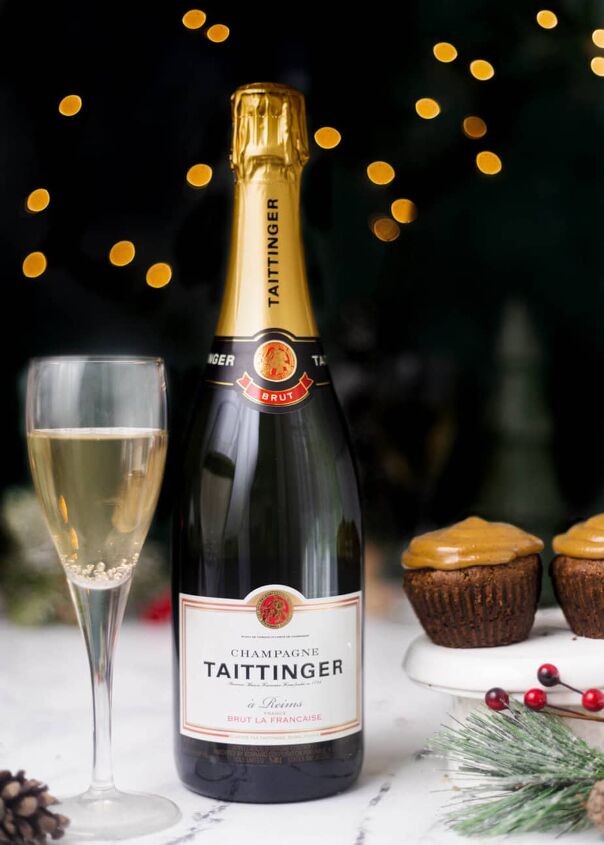 easy small batch gingerbread cupcakes, A gingerbread cupcake next to a bottle of brut and a glass of brut with sparkly lights in background