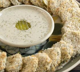 easy crunchy vegan air fried pickles no oil gluten free option, round serving platter with vegan air fried pickle chips arranged in a ring on the outside edge with a bowl of vegan ranch dressing garnished with a pickle slice in the center