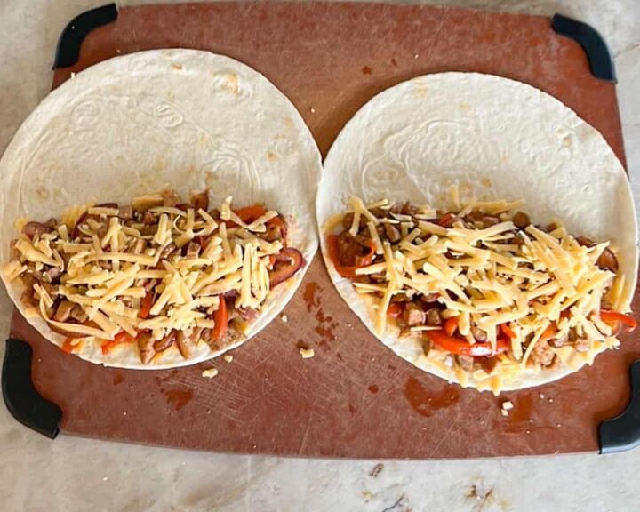 leftover pork tenderloin quesadillas, two tortillas open with pork onion mixture and grated cheese on half of each