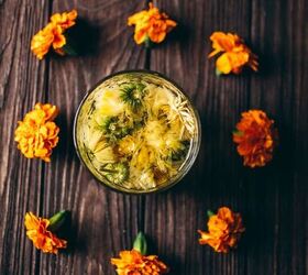 how to make calendula tea, a cup of calendula tea surrounded by fresh bright orange edible flowers
