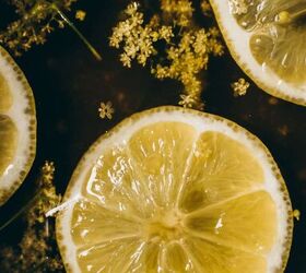 how to make elderflower cordial, lemon slices and elderflowers float atop a cordial in the making