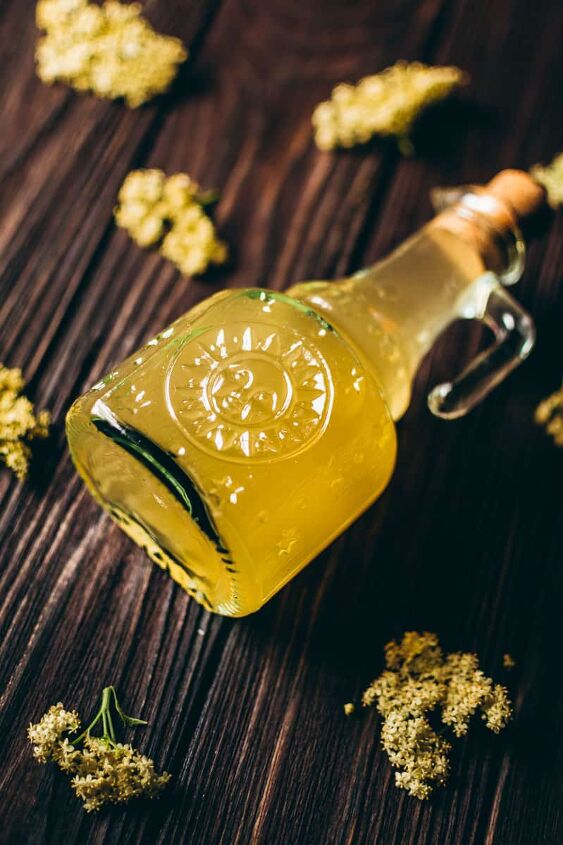 how to make elderflower cordial, a glass sun bottle of elderflower cordial seems to glow from within leaving a magical site of yellow golden liquid