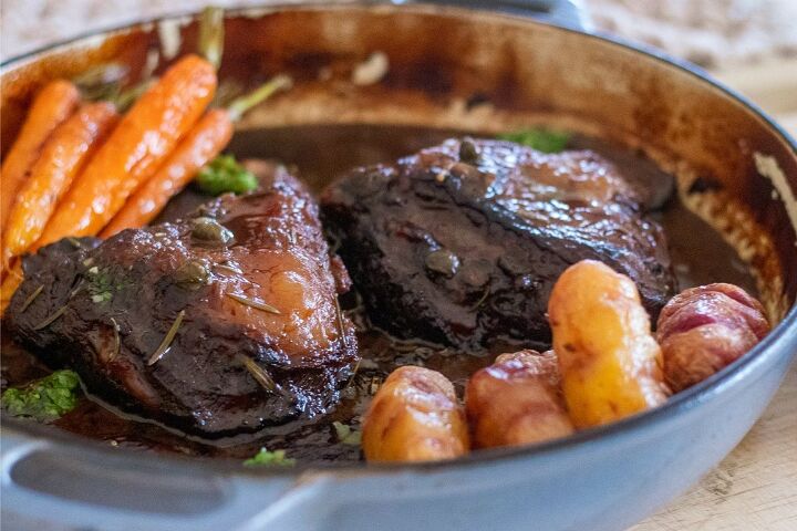 slow braised beef cheeks in a red wine sauce, Slow braised beef served in a dish with a red wine sauce and veg