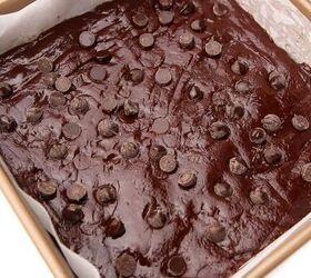 the best vegan brownies, Vegan brownie batter pressing in a pan that has been lined with parchment paper and topped with chocolate chips