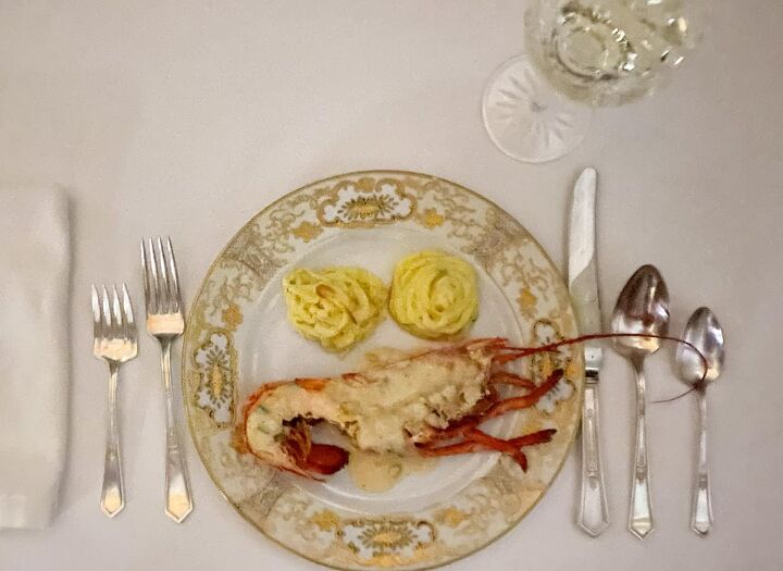 dining on the orient express, china plate with lobster and potatoes on a white table cloth