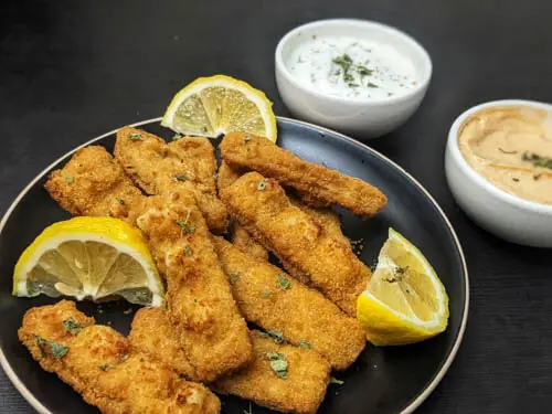 gorton s fish sticks air fryer recipe, gorton s fish sticks in air fryer served on a black plate and served with a side of ranch and chipotle dipping sauce