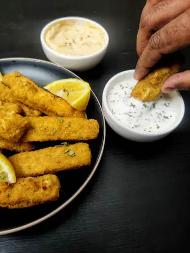 gorton s fish sticks air fryer recipe, a plate full of gorton s fish sticks made in air fryer and one fish stick being dipped in ranch