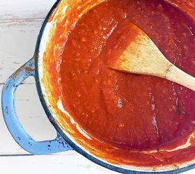 Wooden spoon in a dutch oven filled with San Marzano sauce
