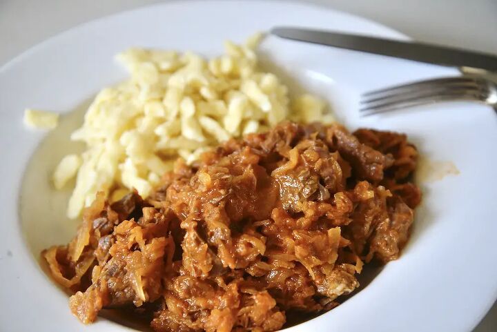 easy hungarian beef goulash recipe, Hungarian beef goulash and German spaetzle on plate with fork and knife