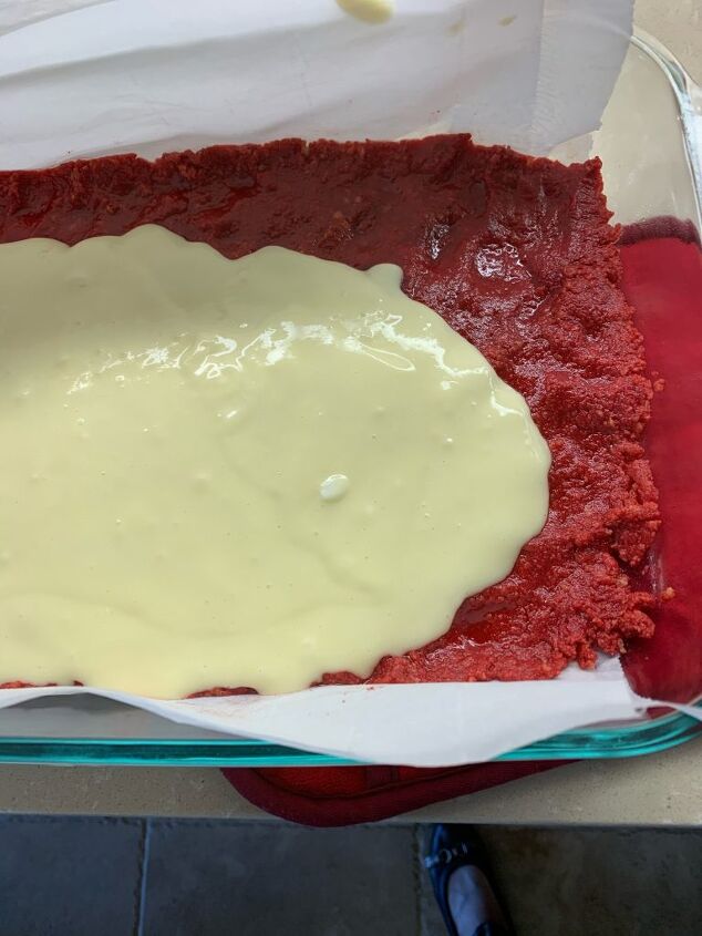Pouring the creamy filling over the red base dough