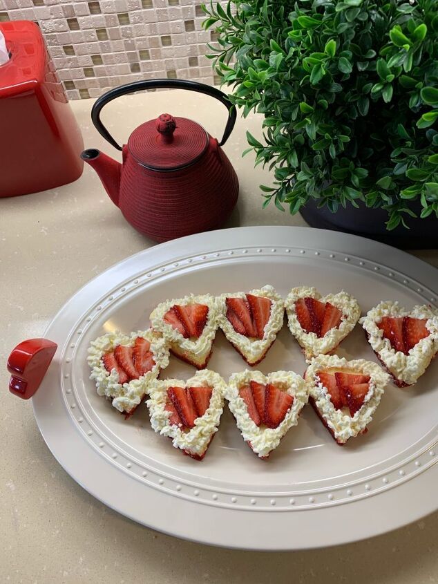 The finished product Heart shaped cheese cakes with strawberries and edged in whipped cream mixture