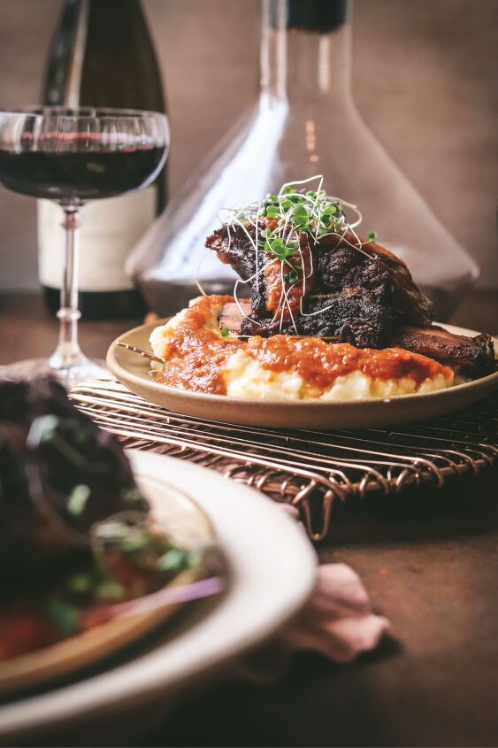 braised beef short ribs, Short rib in front of a red wine decanter