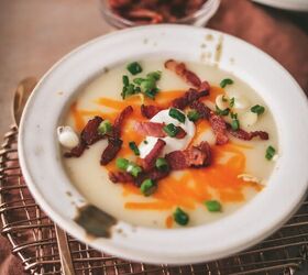 easy potato soup recipe, A bowl of potato soup with napkin trivet and garnishes